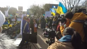 A crowd of people gathered on the side walk