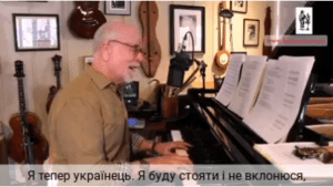 A man sitting at the piano in front of a microphone.