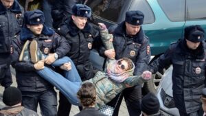 A group of police officers holding up a person.