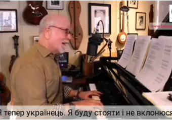 A man sitting at the piano in front of a microphone.