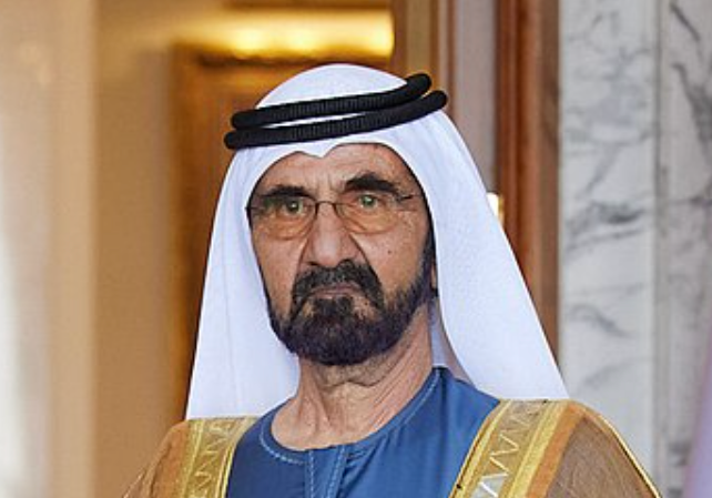 A man with a beard and glasses wearing a white hat.