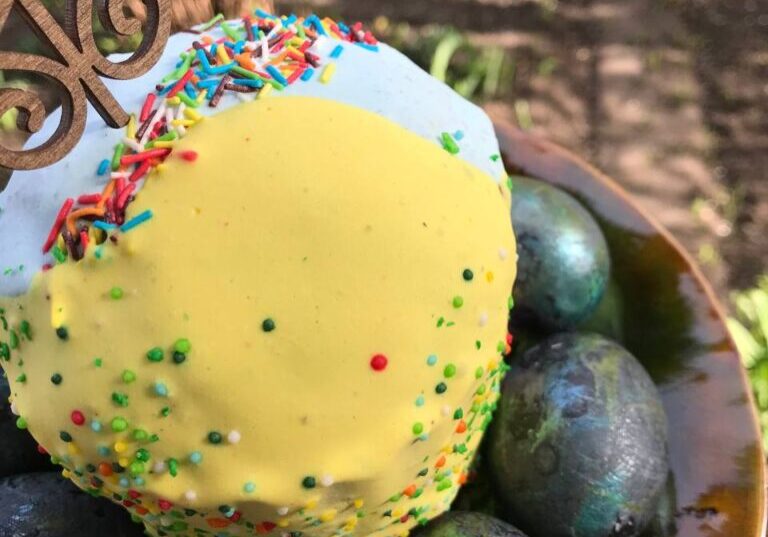 A bowl of fruit with a yellow cake on top.