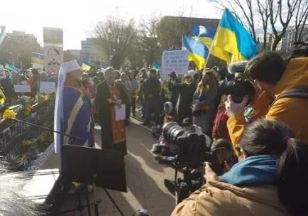 A crowd of people gathered on the side walk